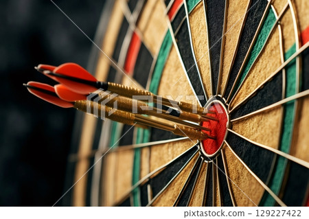 Three darts hitting the bullseye of dartboard showing success and accuracy 129227422