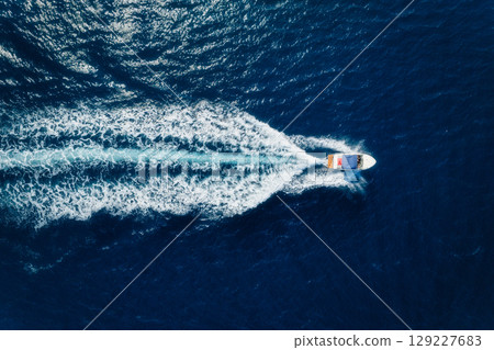 Aerial view on fast boat on blue sea at sunny day. Seascape with motorboat. 129227683