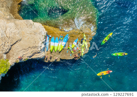 Kayaking. Sup. Aerial view of floating board and people on blue sea at sunny day. 129227691