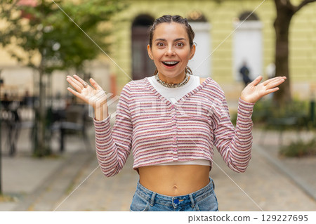 Excited Caucasian young woman tourist walking on urban city street expresses amazement, wow emotion Excited Caucasian young woman tourist walking on urban city street expresses amazement, wow emotion 129227695