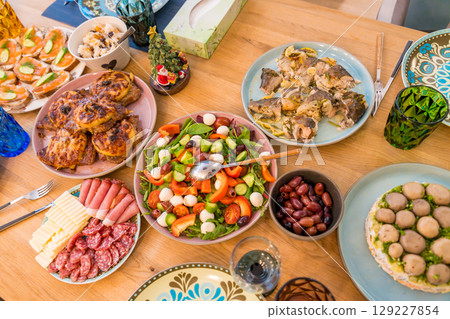 A Top view of a festive Christmas dinner spread on a wooden table. Homemade dishes 129227854