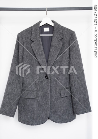 Gray oversized blazer made of faux wool and polyester hanging on hanger for fashion retail 129227909