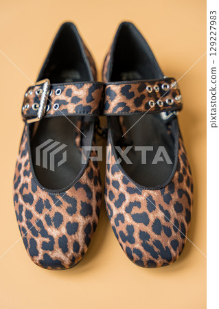 Leopard print ballet flats with buckle detail on beige background 129227983