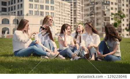 A joyful group of friends is laughing and enjoying time outdoors, showcasing their happiness and togetherness A joyful group of friends is laughing and enjoying time outdoors, showcasing their happiness and togetherness 129228046