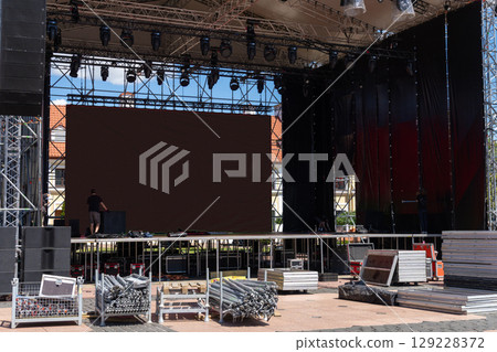 Workers installing sound and stage equipment 129228372