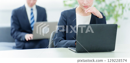 一位商務人士在使用電腦時思考 一位商務人士在使用電腦時思考 129228574