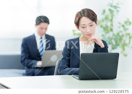 一位商務人士在使用電腦時思考 一位商務人士在使用電腦時思考 129228575