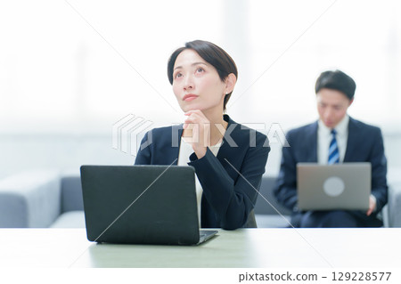 一位商務人士在使用電腦時思考 一位商務人士在使用電腦時思考 129228577