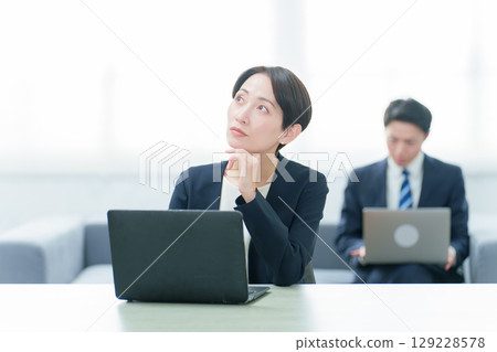 一位商務人士在使用電腦時思考 一位商務人士在使用電腦時思考 129228578