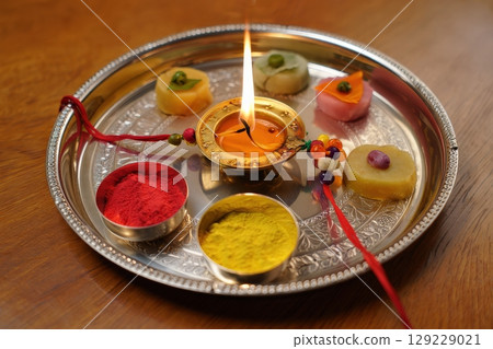 Raksha Bandhan Thali with Diya, Sweets, Kumkum, and Rakhi on Wooden Table Raksha Bandhan Thali with Diya, Sweets, Kumkum, and Rakhi on Wooden Table 129229021