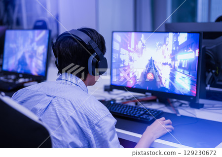 一名男學生坐在遊戲椅上沉浸在遊戲中的背影 129230672