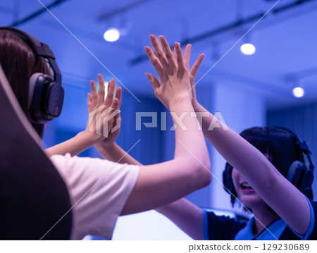 Female students collaborating in e-sports with blue light 129230689