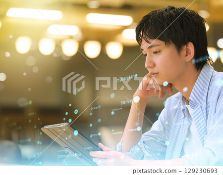 A male student pondering on a tablet device A male student pondering on a tablet device 129230693