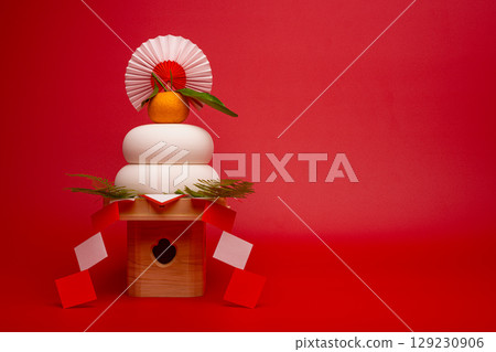左側放置「火神餅」的照片，背景為紅色，底座較高。 129230906