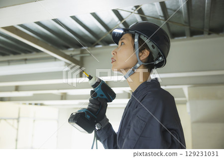 Young female worker working at a construction site 129231031