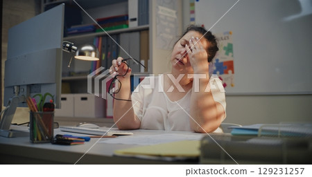 Tired Female Teacher Sitting at Computer in Empty Classroom, Feeling Stress, Burnout 129231257