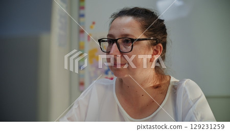 Primary School Teacher Working at PC in Classroom in the Evening Primary School Teacher Working at PC in Classroom in the Evening 129231259