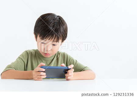 A boy obsessed with his smartphone A boy obsessed with his smartphone 129231336