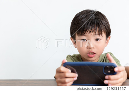 A boy obsessed with his smartphone A boy obsessed with his smartphone 129231337