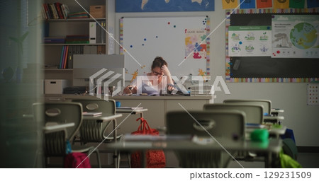 Female Teacher Checking Homework of Students, Grading School Tests After Class Female Teacher Checking Homework of Students, Grading School Tests After Class 129231509