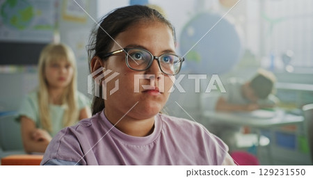 Close Up of Elementary School Girl Raising Hand and Answering Teacher's Question During Geography Lesson Close Up of Elementary School Girl Raising Hand and Answering Teacher's Question During Geography Lesson 129231550