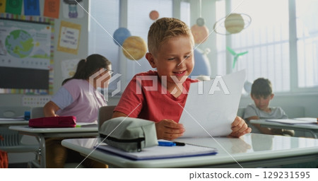 Teacher Giving Papers with School Test Results. Smart Boy Rejoicing and Celebrating Excellent Grade 129231595