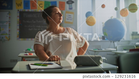 Tired Female Teacher Sitting Alone in Empty Classroom, Feeling Stress, Burnout Tired Female Teacher Sitting Alone in Empty Classroom, Feeling Stress, Burnout 129231616