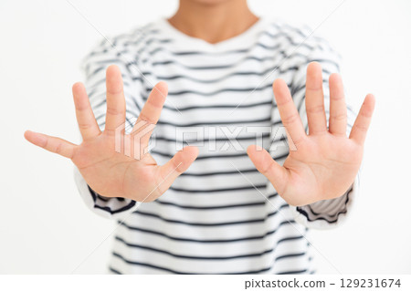 An elementary school boy refusing to accept something with both hands up An elementary school boy refusing to accept something with both hands up 129231674