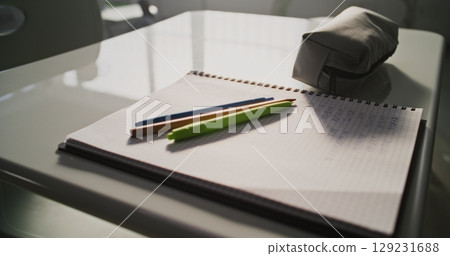 Close Up Shot of School Desk with Student School Supplies: Pencil Case, Pens and Pencils, Notebook 129231688