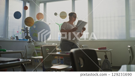 Female Teacher Organizing Space for School Exam in Classroom in Modern Primary School 129231690