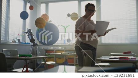 Female Teacher Organizing Space for School Exam in Classroom in Modern Primary School Female Teacher Organizing Space for School Exam in Classroom in Modern Primary School 129231691