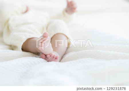 Baby lying on bed 129231876