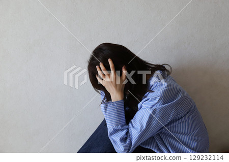 A woman looking down and feeling depressed A woman looking down and feeling depressed 129232114