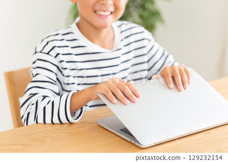 Elementary school boy using a computer at home Elementary school boy using a computer at home 129232154