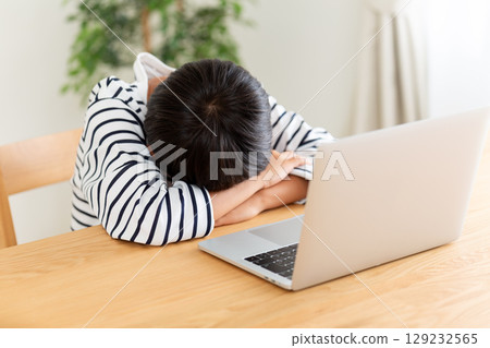 An elementary school boy depressed in front of a computer at home 129232565