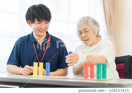Occupational therapists working at nursing and rehabilitation facilities and senior women undergoing rehabilitation 129233423