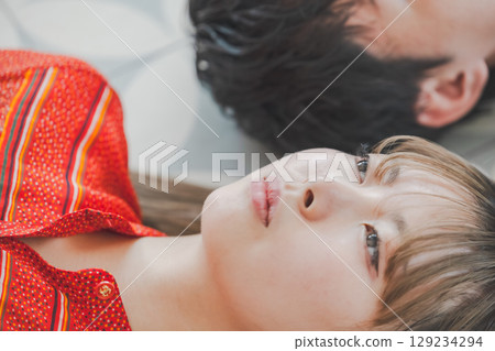 The gazes of a man and woman lying on the floor intersect The gazes of a man and woman lying on the floor intersect 129234294