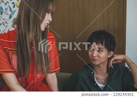 Fashion snap of a man and woman gazing into each other's eyes 129234301