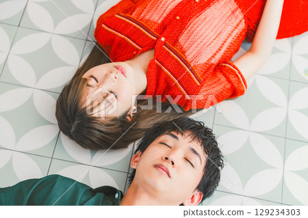 一男一女並排躺在地板上的肖像 129234303