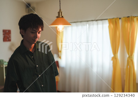 A young man standing under the lamplight A young man standing under the lamplight 129234340