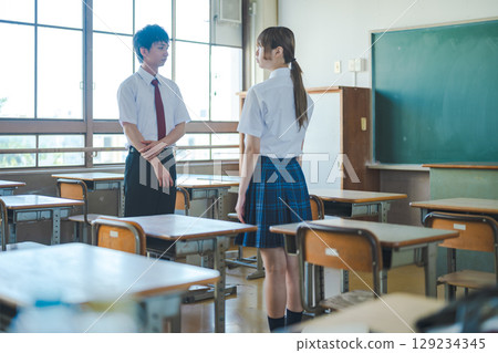 Male and female high school students talking in the classroom 129234345