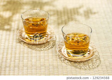 A cool glass of barley tea and a tea tray placed on the tatami mat A cool glass of barley tea and a tea tray placed on the tatami mat 129234388
