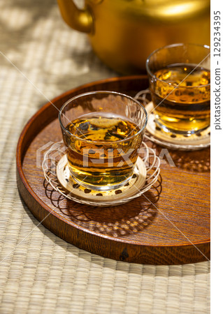 Glasses of barley tea and a kettle lined up on a tray placed on a tatami mat Glasses of barley tea and a kettle lined up on a tray placed on a tatami mat 129234395