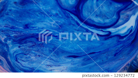 Emulsion blend. Vibrant sparkling texture. Defocused blue white color paint glitter particles liquid spill on abstract art background. Emulsion blend. Vibrant sparkling texture. Defocused blue white color paint glitter particles liquid spill on abstract art background. 129234772