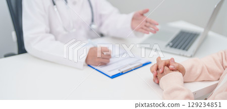 senior woman consulting with doctor in hospital. Elderly patient talking and sharing disease. Doctor listens, asking question and taking note. medical consultation and geriatric Healthcare concept senior woman consulting with doctor in hospital. Elderly patient talking and sharing disease. Doctor listens, asking question and taking note. medical consultation and geriatric Healthcare concept 129234851