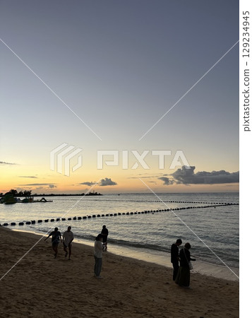 People playing in the ocean at dusk in Okinawa 129234945