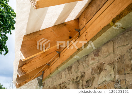Timber Roof Construction with Insulation on Stone Wall. Sustainable Architecture and Home Renovation 129235161