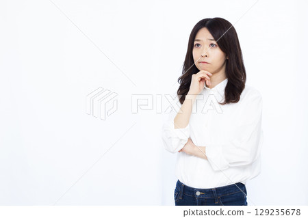 A woman who is thinking with her arms crossed A woman who is thinking with her arms crossed 129235678