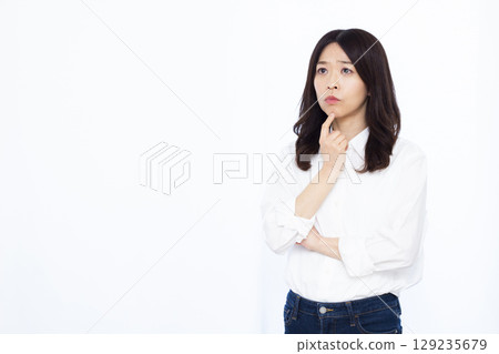 A woman who is thinking with her arms crossed 129235679