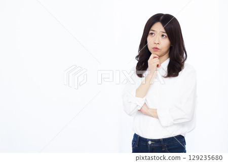 A woman who is thinking with her arms crossed 129235680